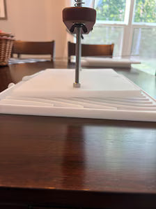 A side view of the base elevated by the draining foot to push whey in one direction